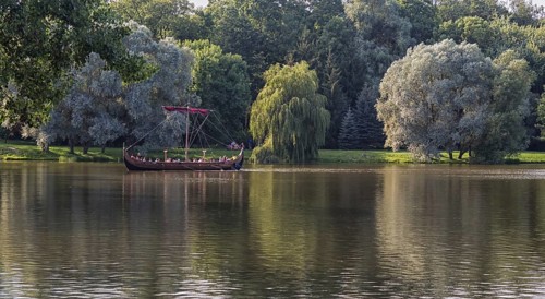 A large wooden boat with tourists floats on the lake. Belarus