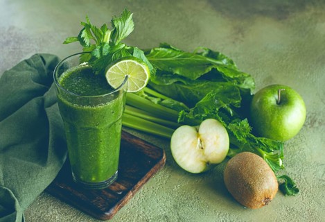 Glass, with green smoothie, celery and spinach, apple and kiwi, cucumber, with ingredients on the
