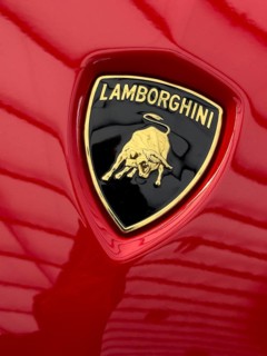 Logo with Lamborghini lettering and stylised fighting bull from sports car manufacturer on red