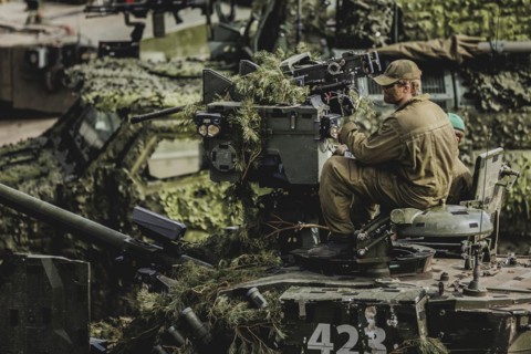 A soldier sits on a tank, taken as part of a Bundeswehr exercise with armed forces from Norway and