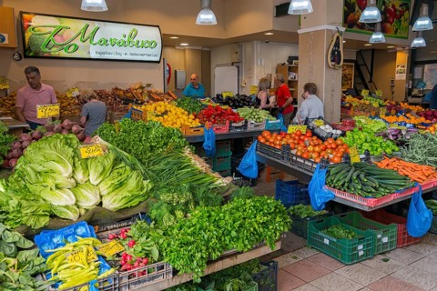 Lively vegetable market with a variety of fresh produce and people shopping, market hall, Xanthi,