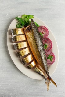 Smoked mackerel, top view, with spices, on a wooden table, no people, selective focus