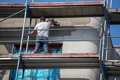 Painter painting the façade of a new apartment building