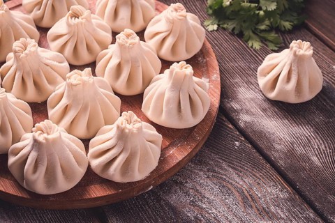 Raw khinkali, Traditional Georgian dish, on a wooden table, selective focus, rustic, no people