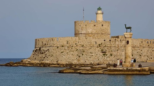 People strolling past a column near an old fortress by the sea, Fort of Saint Nikolaos, European
