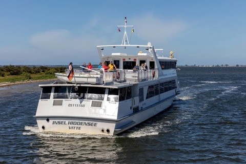 Island ship with passengers on the upper deck sailing across the sea on a sunny day, Rügen