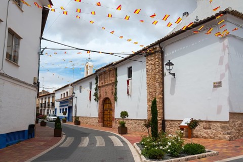 A decorated street with Spanish flags and white-painted houses, Ermita de la Vera Cruz, hermitage,