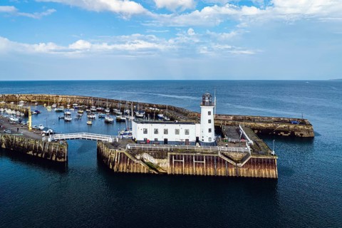 Scarborough Lighthouse and Harbour from a drone, Vincent Pier, Scarborough, North Yorkshire,