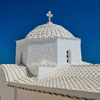 Cross-domed church Diasososuan, detailed view of a white church with dome under a bright blue sky,