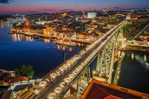 View of illuminated Porto city and Douro river and Dom Luis bridge I from famous tourist viewpoint