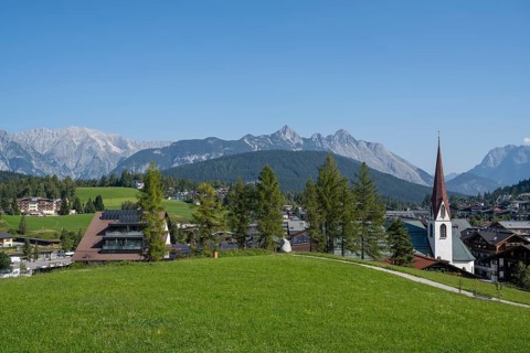 View of the village with St Oswald parish church, Karwendel mountains, view from the parish hill,