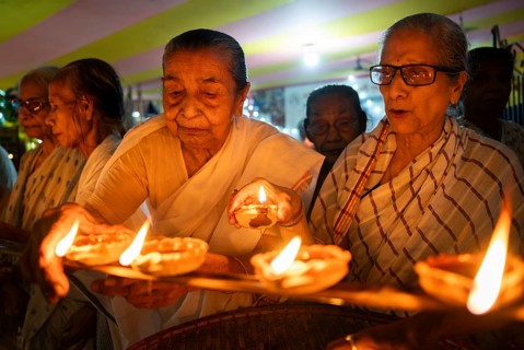 Elderly women of Pramod Talukdar Memorial Old Age Home light Diya oil lamps as they celebrate