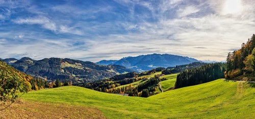 Wide green meadows against a mountain backdrop under a blue sky, Spitzstein