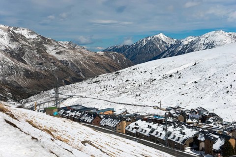 Ein Dorf in den schneebedeckten Bergen, mit einer Straße, Skigebiet, El Pas de la Casa,