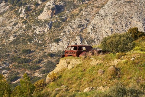 Abandoned rusted car on a rocky meadow in front of majestic mountains, Vehicle wreck, Crete, Greek