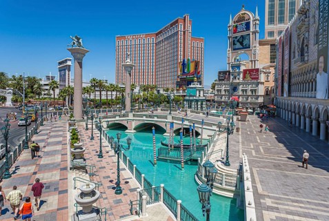 Treasure Island hotel and casino rises up beyond the pools of the Venetian resort on the Las Vegas