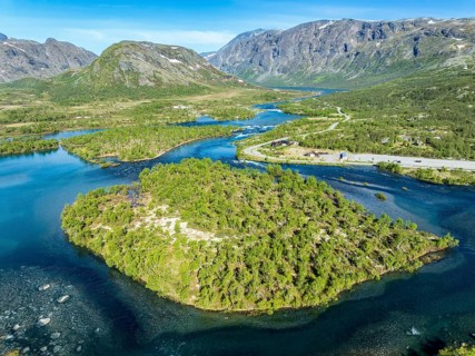Islands in river Sjoa, famous Besseggen ridge in the back, road to Gjendesheim tourist hut, aerial
