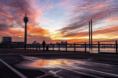Winter sunset on the Rhine near Düsseldorf, riverside promenade at the old town, Rhine Tower, cargo