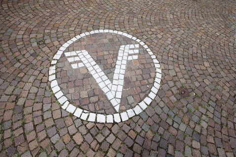 White floor mosaic with Volksbank emblem, paving stones, floor, logo, trademark, bank, sign, V,