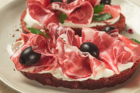 Sandwich with cream cheese, prosciutto with olives, breakfast