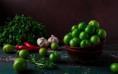 Tkemali, green cherry plum, with ingredients for sauce, cilantro, mint, hot pepper, garlic, on a