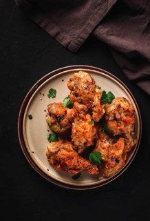 Fried chicken legs, breaded, with spices and herbs, on a dark background, vertical, no people,