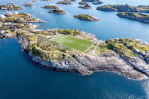 Aerial view over football stadium on rocky island, fishing village Henningsvaer, Lofoten, Norway,