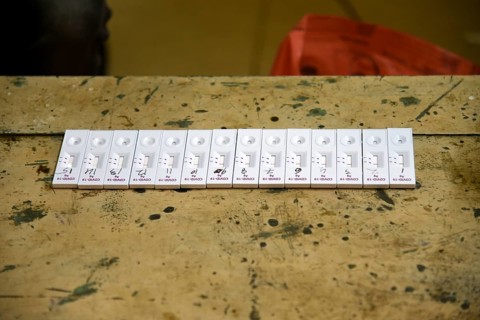 A health worker in personal protective equipment (PPE) arranges test kit after taking nasal swab