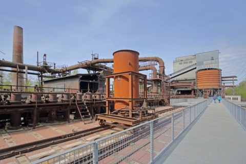 Coking plant with wagon on rails, pipelines, buildings and tourists, UNESCO Völklingen Ironworks,