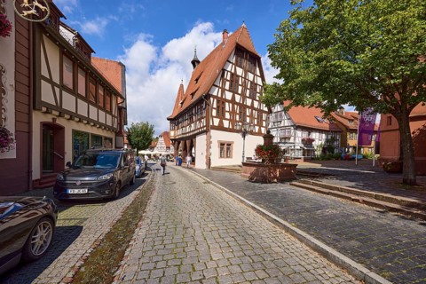 Historic town hall on Braunstraße with half-timbered houses, blue sky and cumulus clouds in