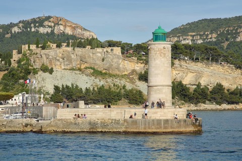 Lighthouse and people, houses on rocks on the shore, Mediterranean coast, bay, mountains, Cassis,