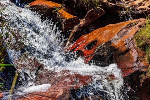 Water from a small waterfall splashing over rocks in Minas Gerais, Minas Gerais, Brazil, South