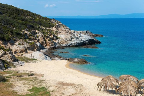 Lonely coastal landscape with clear water, rocky shores and a quiet beach under a blue sky, beach,