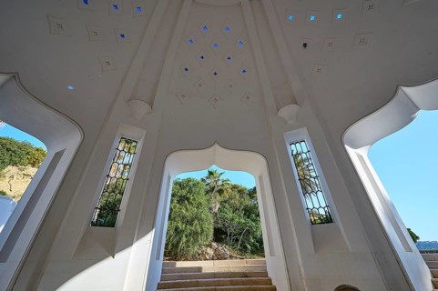 Interior of a white domed structure with large windows and bright light patterns on stairs, thermal