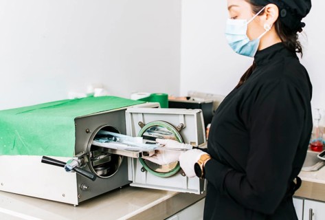 Dentist with a dental sterilizer, A dentist sterilizing his tools, A dentist with a dental