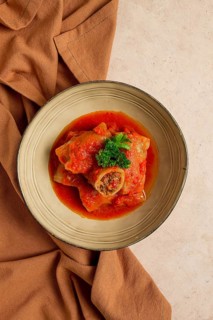 Stuffed cabbage rolls, with minced meat, in tomato sauce, on a beige background, food and drink,