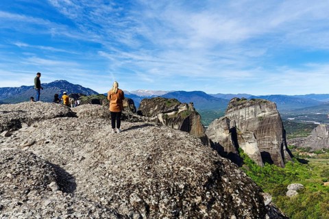 Group of tourists on rocks, enjoying the view, Meteora Trail, blue sky, Thessaly, Greece, Europe