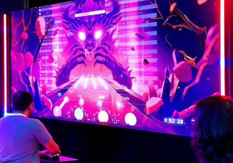 Visitors in front of a large screen with the Toxic Monster, which lives from hate on the Internet,