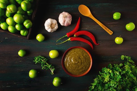 Tkemali sauce, traditional Georgian cuisine, green cherry plum, with ingredients for sauce,