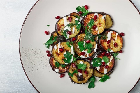 Fried eggplant, with white sauce, pomegranate seeds, top view, no people