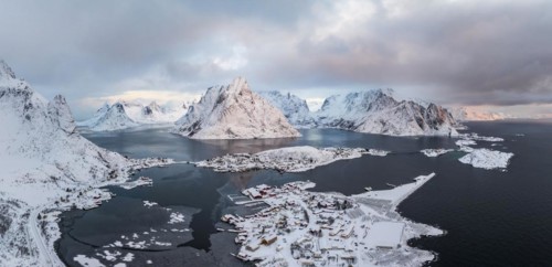 View of snow-covered islands, fjord and mountains, fishing villages Sakrisøy and Reine, Reinefjord,
