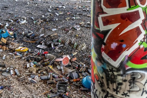 Empty spray paint cans, on a railway line below a road bridge, thrown away, disposed of by the