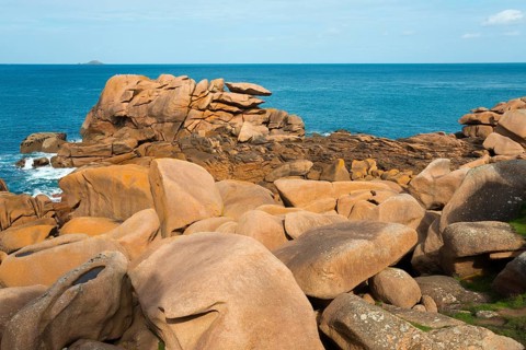 Orange-coloured rocks on the blue ocean under a slightly cloudy sky, Ploumanac'h, Ploumanach,