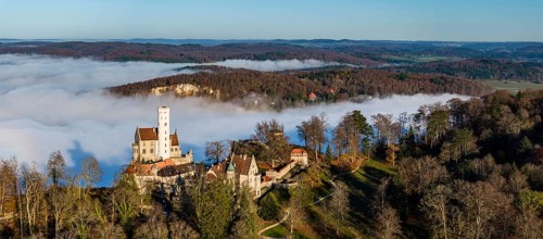 Sunshine in the mountains, fog in the Echaz valley. Lichtenstein Castle in the Swabian Alb. The