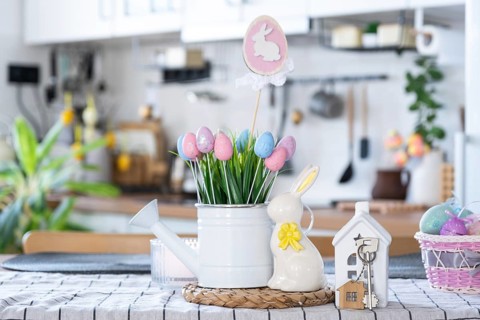 Key to house of cozy home with Easter decor with rabbit and eggs on table of kitchen. Building,