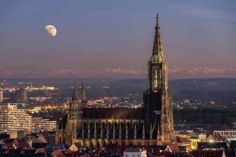 Composite of Minster in Ulm with mountain range Alps and full moon