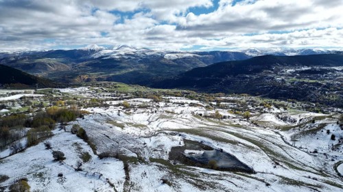 Aerial view of snow-covered fields and distant mountains under a cloudy sky. Posof, Ardahan, TURKEY