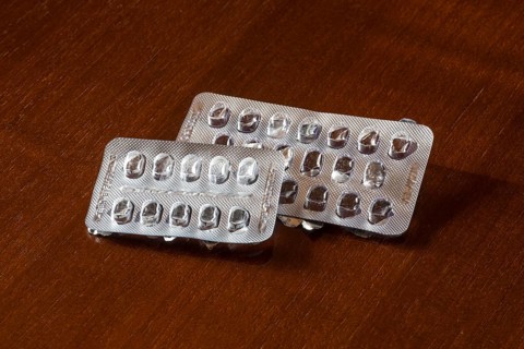 Empty blister packs on a brown wooden surface