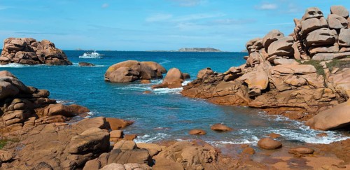 Rocky landscape with blue water and a boat on the horizon, Ploumanac'h, Ploumanach, Perros-Guirec,