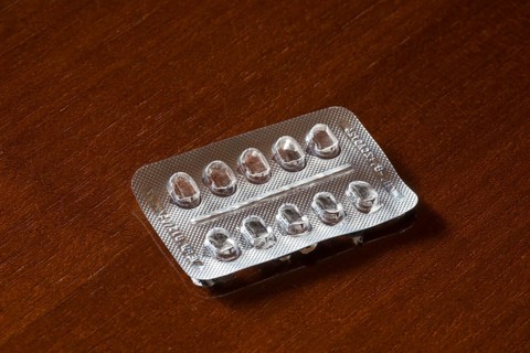 Empty blister packaging on a brown wooden surface